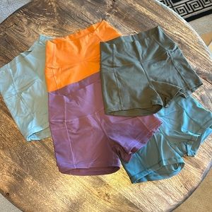 5 pairs of athletic shorts size XS in different colors.